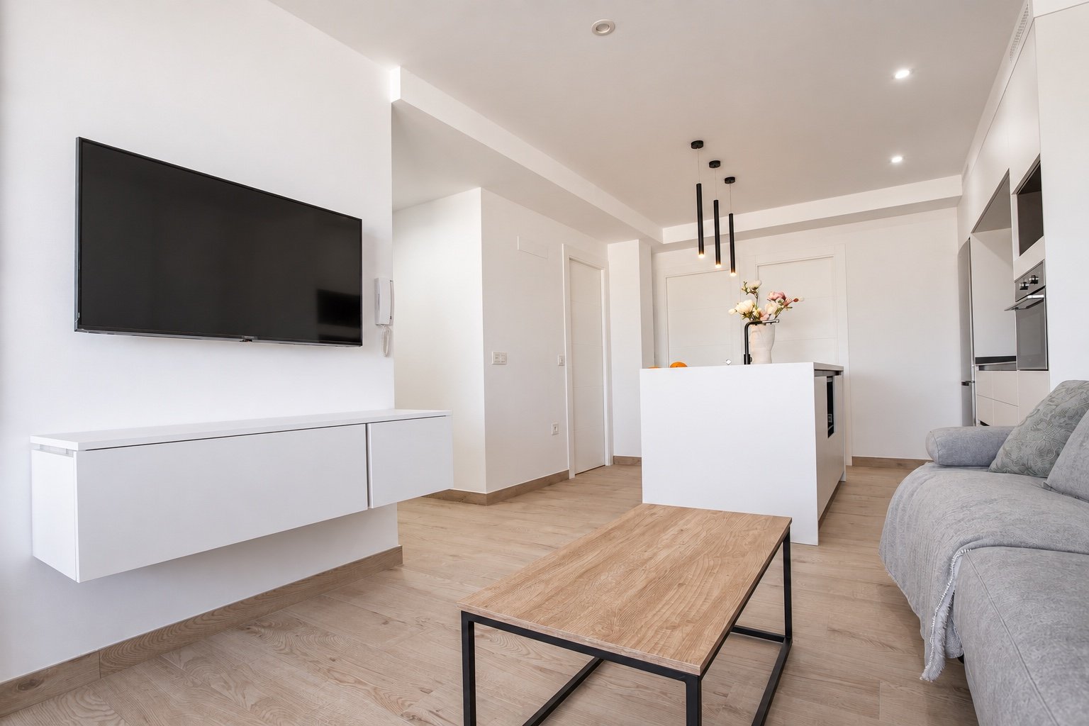 Vista general del salón y la cocina abierta de un pequeño apartamento reformado en Almerimar