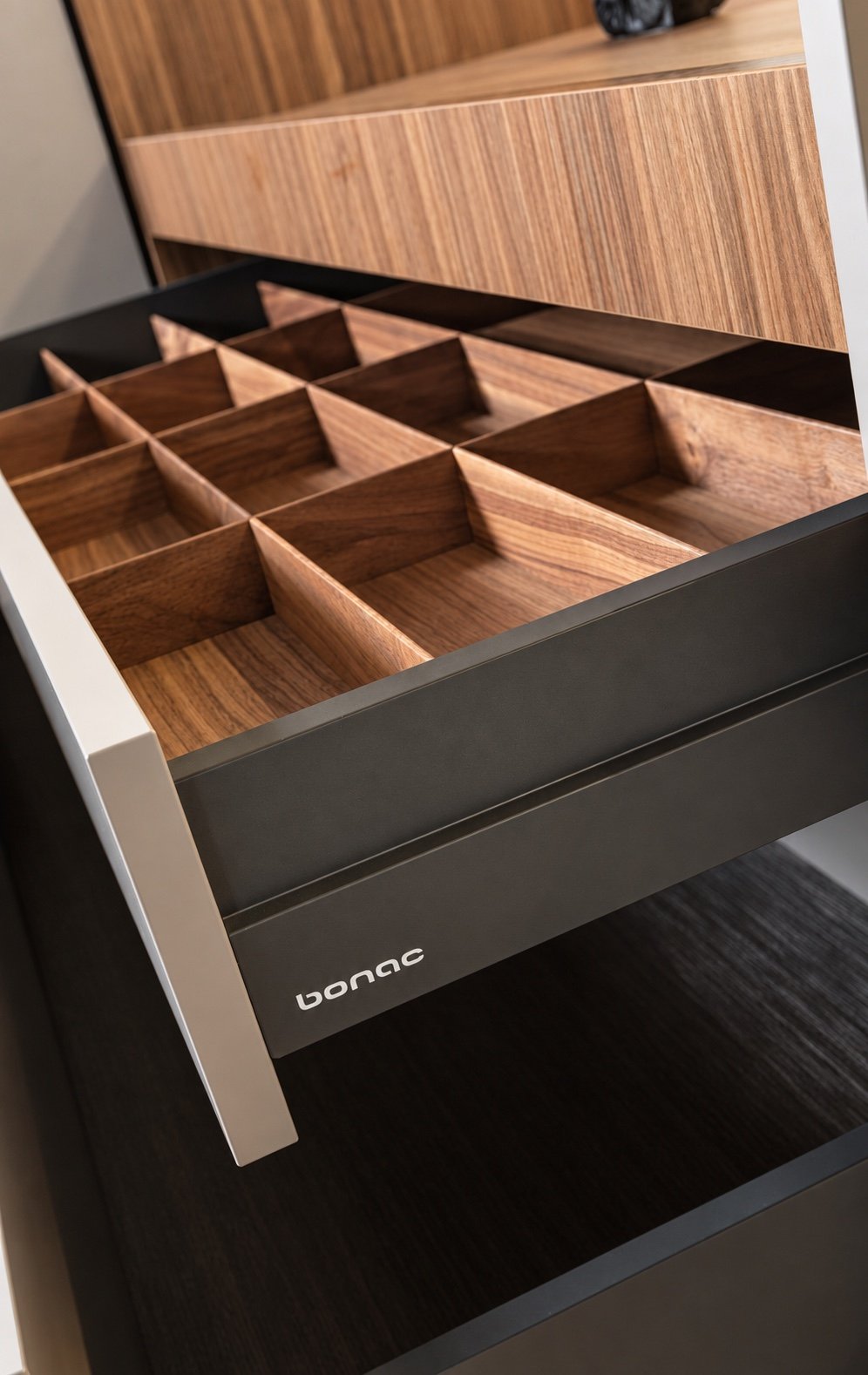 Detalle interior de cajón con divisores de madera y herrajes negros