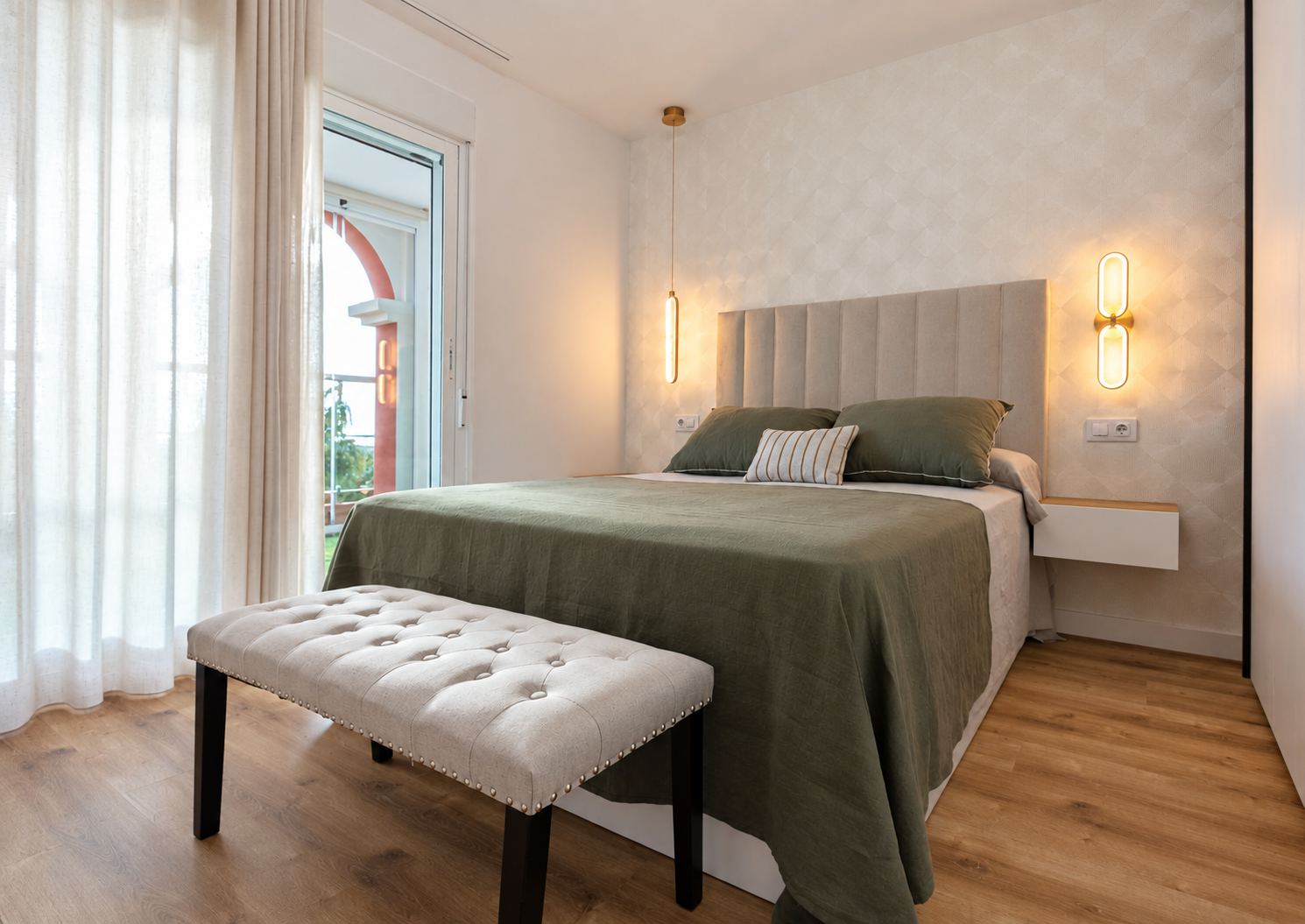 Dormitorio con luz lateral, cama verde oliva, cabecero tapizado y banco claro